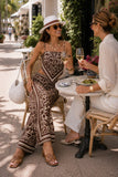 ASTR the Label Eva Pant Style ACP7429 in Brown Tropical. Woman enjoying lunch outdoors in Palm Beach wearing a coordinated brown botanical print resort matching set.