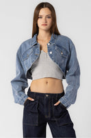 “Beige Botany asymmetrical cropped denim jacket in medium denim wash. Style Number A2450J A stylish, contemporary jacket with an asymmetrical design, crafted in a versatile medium denim wash. The cropped length pairs well with high rise bottoms and a fitted top, creating a fashionable and confident ensemble.”