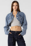 “Beige Botany asymmetrical cropped denim jacket in medium denim wash. Style Number A2450J A stylish, contemporary jacket with an asymmetrical design, crafted in a versatile medium denim wash. The cropped length pairs well with high rise bottoms and a fitted top, creating a fashionable and confident ensemble.”