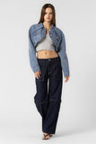 “Beige Botany asymmetrical cropped denim jacket in medium denim wash. Style Number A2450J A stylish, contemporary jacket with an asymmetrical design, crafted in a versatile medium denim wash. The cropped length pairs well with high rise bottoms and a fitted top, creating a fashionable and confident ensemble.”