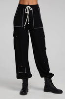 A pair of Chaser Billy Shadow Black Jogger Pants featuring contrast stitching, side cargo pockets, an elastic waist, and deep front pockets. The joggers are shown paired with the matching Cooper Shadow Black Top, creating a stylish and comfortable ensemble. Style Number CW9769-SHDW