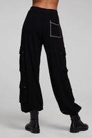 A pair of Chaser Billy Shadow Black Jogger Pants featuring contrast stitching, side cargo pockets, an elastic waist, and deep front pockets. The joggers are shown paired with the matching Cooper Shadow Black Top, creating a stylish and comfortable ensemble. Style Number CW9769-SHDW