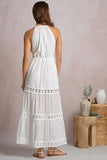 Elan Clothing Soyrara Halter Maxi Dress Style VCL50197 in White. Viscose blend white midi dress with tired eyelet skirt details, halter neck and tie waist for shaping