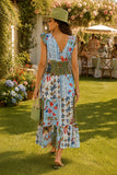 Woman wearing a colorful smocked patchwork print midi dress with a deep V-neckline, green sun hat, woven handbag, green sunglasses, and croc leather flip flops at an elegant summer garden party. Felicite Clothing Smocked Dress style 3911-41890 in french blue.