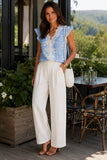 Generation Love Clothing Arden Lace Combo Floral Voile Blouse Heritage Toile Style W02654649 In Heritage Blue with White. Woman in a blue floral lace blouse and ivory wide-leg trousers with friends at a scenic winery lunch, styled with cognac block heel sandals and a woven shoulder bag.