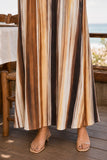 Greylin Clothing Stella Vertical Watercolor Maxi Dress Style G266D7133 in Mustard Brown Neutral Stripe. Close-up of the flowing hem and vertical mustard-brown watercolor print on the Stella Maxi Dress