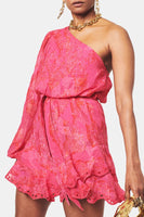 A pink Hemant & Nandita Indu Mini Dress with a shimmery fabrication. The dress features a ruffle tiered hem, self-tie drawn waist, and a one-shoulder silhouette, creating a modern and elegant look.