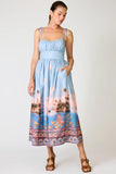 Line and Dot Clothing Pernille Maxi Dress Style LD6071B in Blue Multi. Tie adjustable spaghetti strap partial smocked back summer tropical landscape print maxi dress