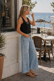 Rails Clothing Akira Top Style 229-615C-001 in black; Side view of Rails Akira black linen top styled with wide leg jeans at a coastal cafe