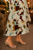 Close-up of the flowing drop waist hem and floral print of the Dolly mesh midi dress paired with clear kitten heel slide sandals. Rails Clothing Dolly Dress Style 566-103H-8745 in Plumeria