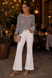 Woman wearing the Evangeline ivory and dark navy striped open-weave linen blend sweater with white flare jeans and clear strap kitten heels. Rails Evangeline Sweater Style 826D-350D-8756 in Ivory Indigo Stripe.