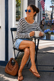 Woman seated wearing the Evangeline ivory and dark navy striped open-weave linen blend sweater with pleated denim shorts for a daytime look. Rails Evangeline Sweater Style 826D-350D-8756 in Ivory Indigo Stripe.