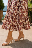Close-up of the flowing chiffon midi hem paired with clear strap kitten heel slide sandals and a loose gold halo anklet. Rails Clothing Marciana Dress Style 913A-191G-8768 in Cardinal Floral