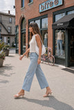 Rails Angeleno light-wash wide-leg crop jeans styled with a sleeveless knit top and clear kitten-heel sandals.