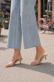 Cropped hem of Rails Angeleno wide-leg jeans styled with clear single-strap kitten-heel sandals.
