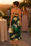 Woman wearing a tropical print beaded halter maxi dress with an open back, styled for a luxury resort vacation, beach dinner, destination wedding, or summer evening event. Steve Madden Apparel Strada Dress Style XB14040 in Golden Palm.
