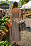 Vava By Joy Han Pom-Pom Maxi Sleeveless Dress Style VAVD119895 in Taupe. Taupe summer maxi dress with pom-pom detail adjustable spaghetti straps. Perfect for warm weather gatherings