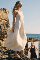 Woman in a white dress standing on rocky terrain by the ocean, with a smaller inset of her in a black dress.