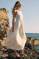 Woman in a white dress standing on rocky terrain by the ocean; Z Supply Clothing Charlotte Ribbed Midi Dress Style ZD253191 in Crystal and in Black; 