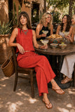 Z Supply Clothing Scout Linen Pant style ZP261545 CHP in Chili Pepper. Woman seated with friends wearing the red Scout Linen Pant for margaritas and lunch on a shaded Scottsdale patio