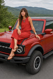 Z Supply Clothing Sloane Linen Cropped Tank Top Style ZT261576 CHP in Chili Pepper. Woman wearing the red Sloane Linen Cropped Tank and matching Scout Pant while seated on a red Bronco